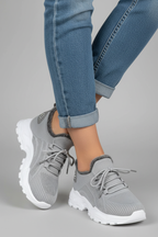 Sneakers grises pies cruzados